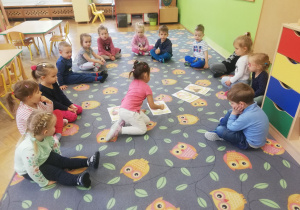 Dzieci uczestniczą w zajęciach na dywanie